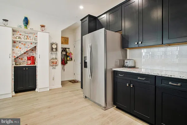a kitchen with granite countertop stainless steel appliances and refrigerator