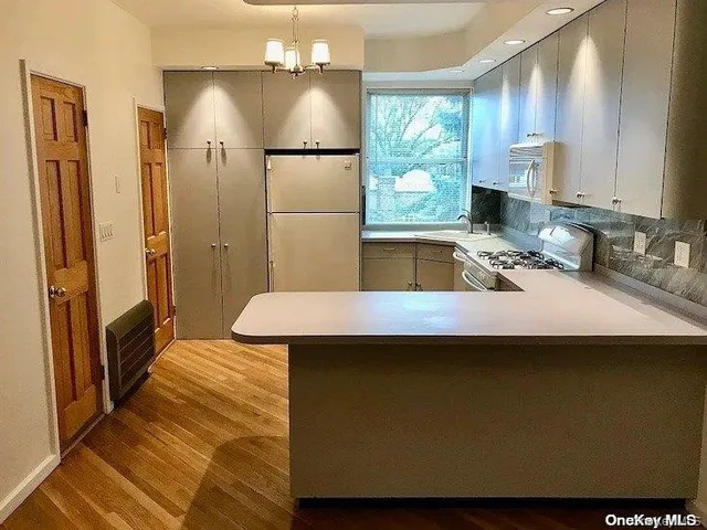a kitchen with a sink a refrigerator and a cabinet