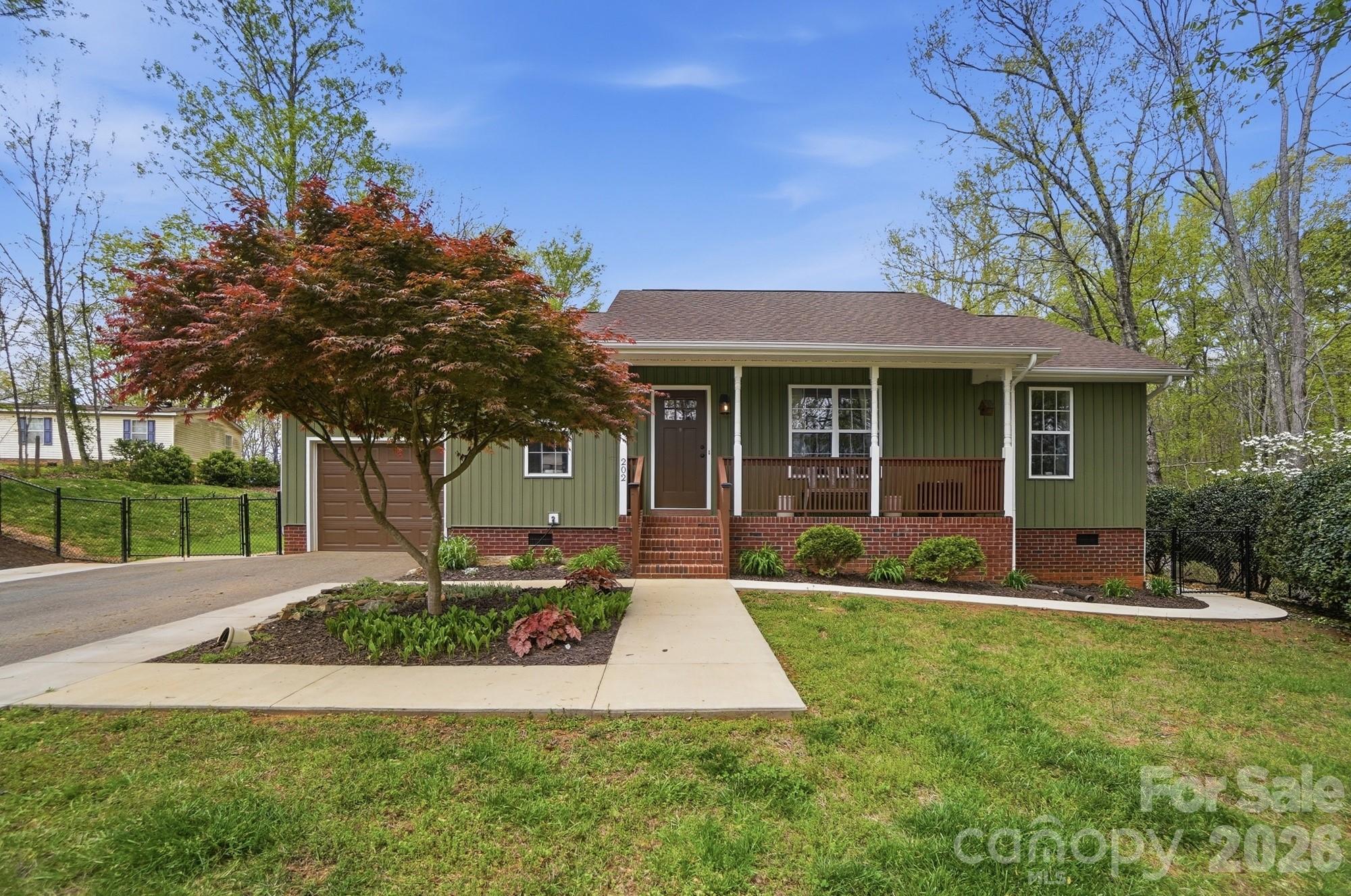 a front view of a house with a yard and trees