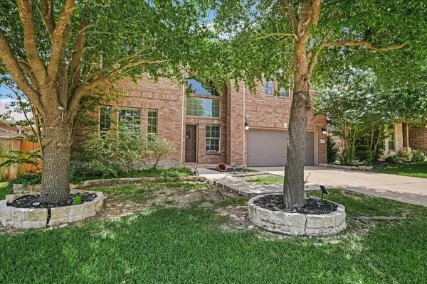 a front view of a house with a yard and fountain