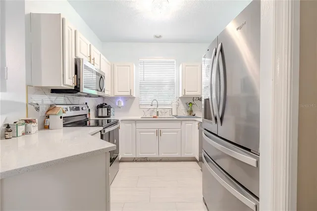 a kitchen with stainless steel appliances granite countertop a sink a stove and cabinets