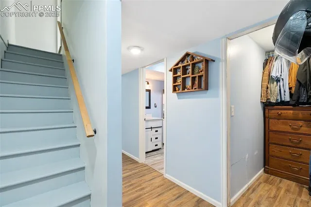a view of a hallway with wooden floor and staircase