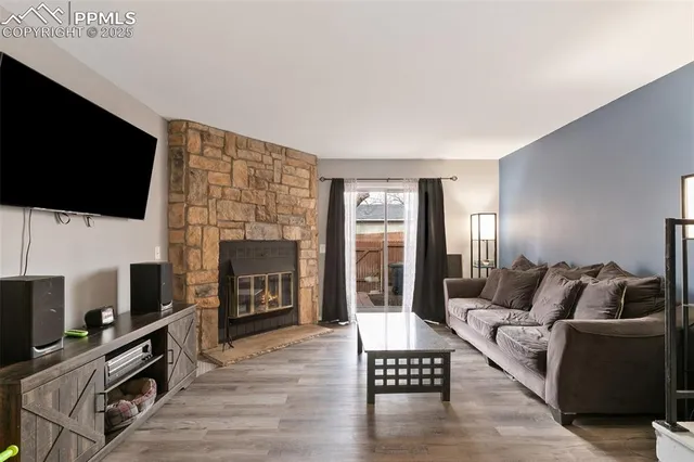 a living room with furniture a flat screen tv and a fireplace