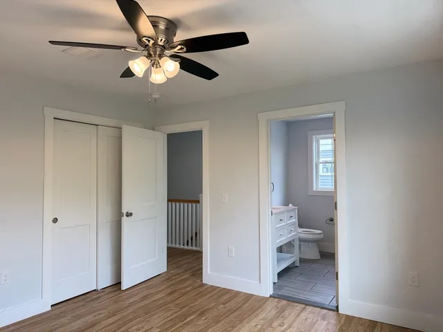 a view of a room with wooden floor and a ceiling fan