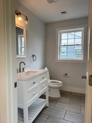 a bathroom with a double vanity sink a mirror and a toilet
