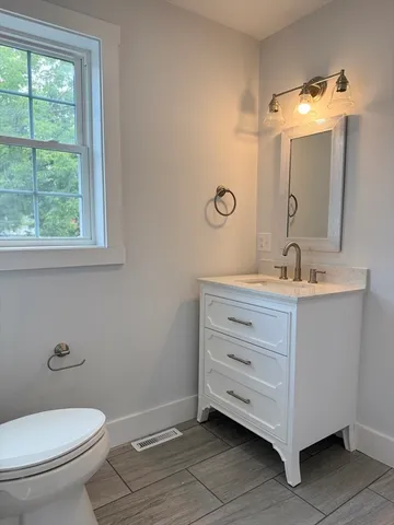 a bathroom with a double vanity sink toilet and a mirror