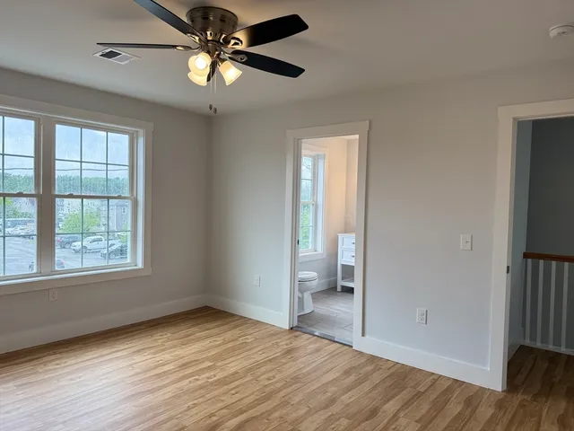 a view of an empty room with a window and a kitchen