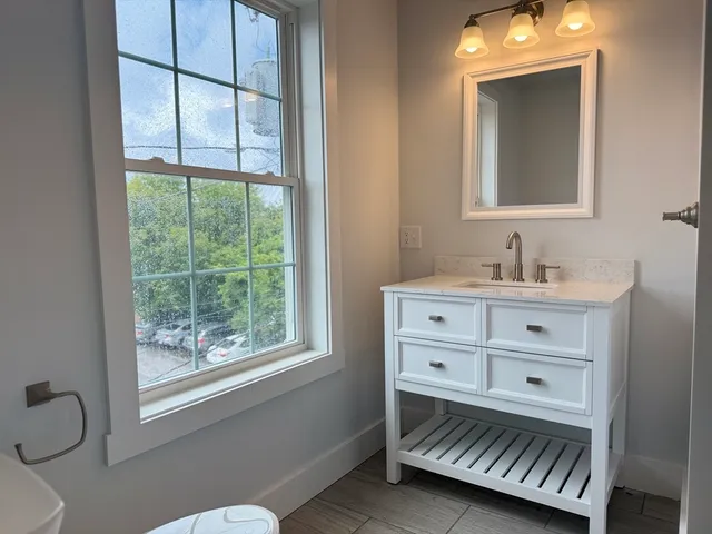 a bathroom with a sink a mirror and a window