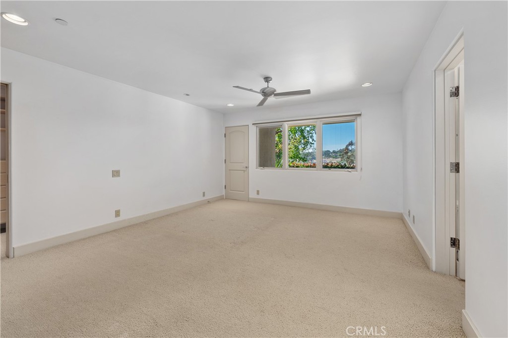 6533 Lago Lindo Rancho Santa Fe, CA 92067 - Photo 33 of 57 an empty room with windows and ceiling fan
