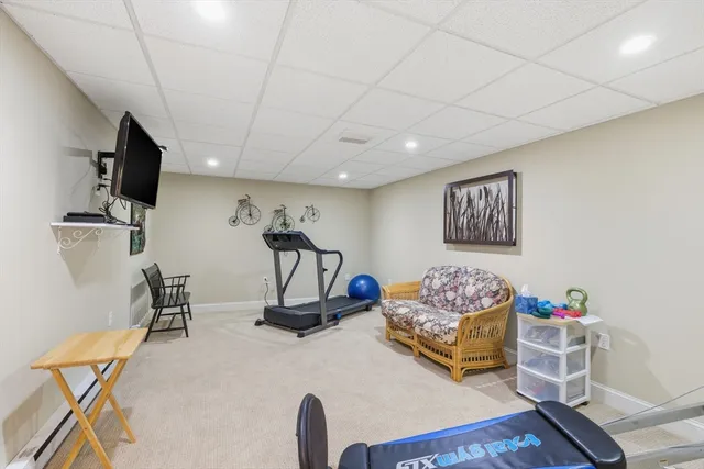 a living room with furniture gym equipment and a flat screen tv