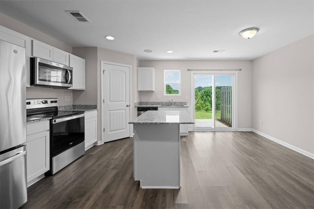 115 Adger Road Pendleton, SC 29670 - Photo 7 of 36 A well-lit kitchen with sleek appliances and an inviting island seamlessly flows to outdoor green spaces.