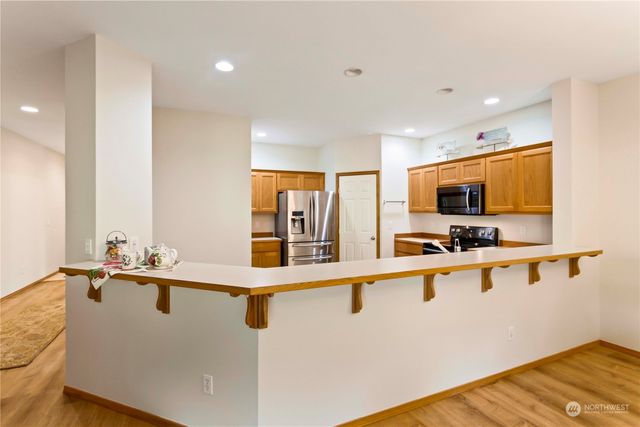 a large white kitchen with a sink and a large window