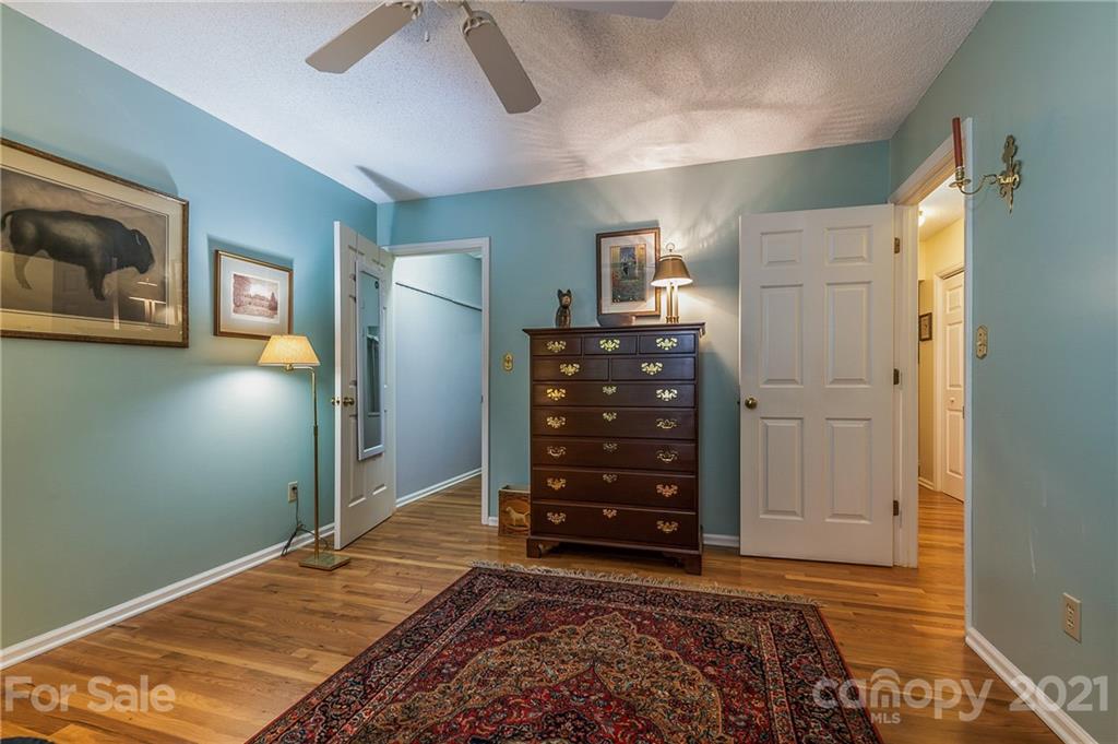 77 Chestnut Street, Unit 402 Tryon, NC 28782 - Photo 22 of 35 a bedroom with a bed and a dresser
