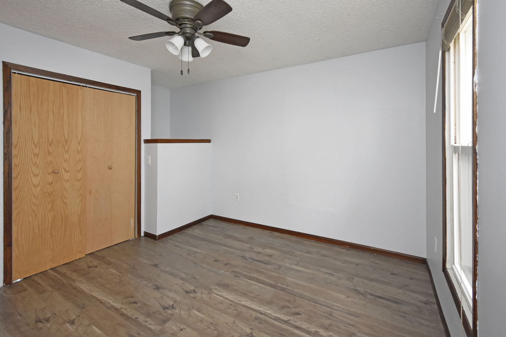 615 North Mulberry Street Clinton, IL 61727 - Photo 27 of 40 an empty room with wooden floor fan and windows