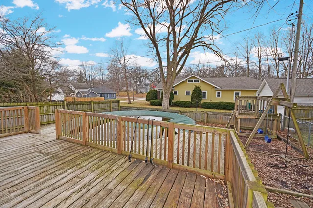 a view of a wooden deck with large trees