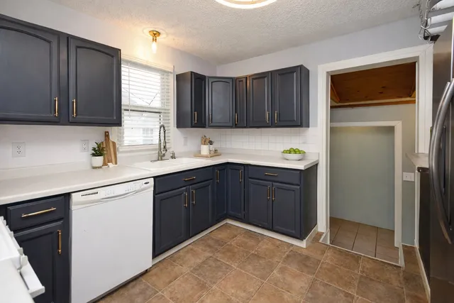 a kitchen with a refrigerator sink and cabinets