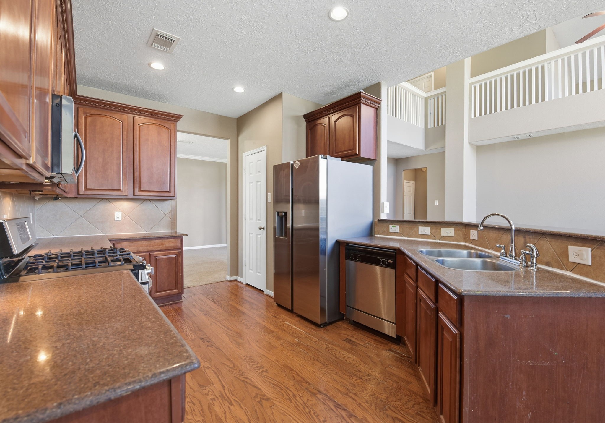13902 Oneida Court Cypress, TX 77429 - Photo 11 of 48 a kitchen with kitchen island granite countertop a sink stove and refrigerator