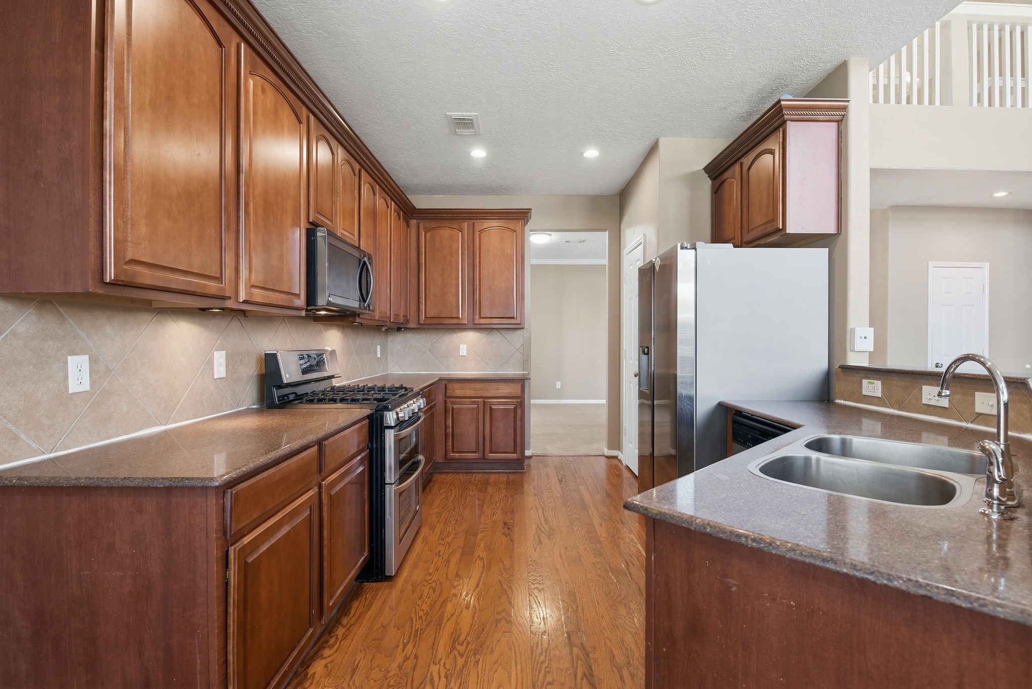 13902 Oneida Court Cypress, TX 77429 - Photo 12 of 48 a kitchen with stainless steel appliances granite countertop a sink stove and refrigerator