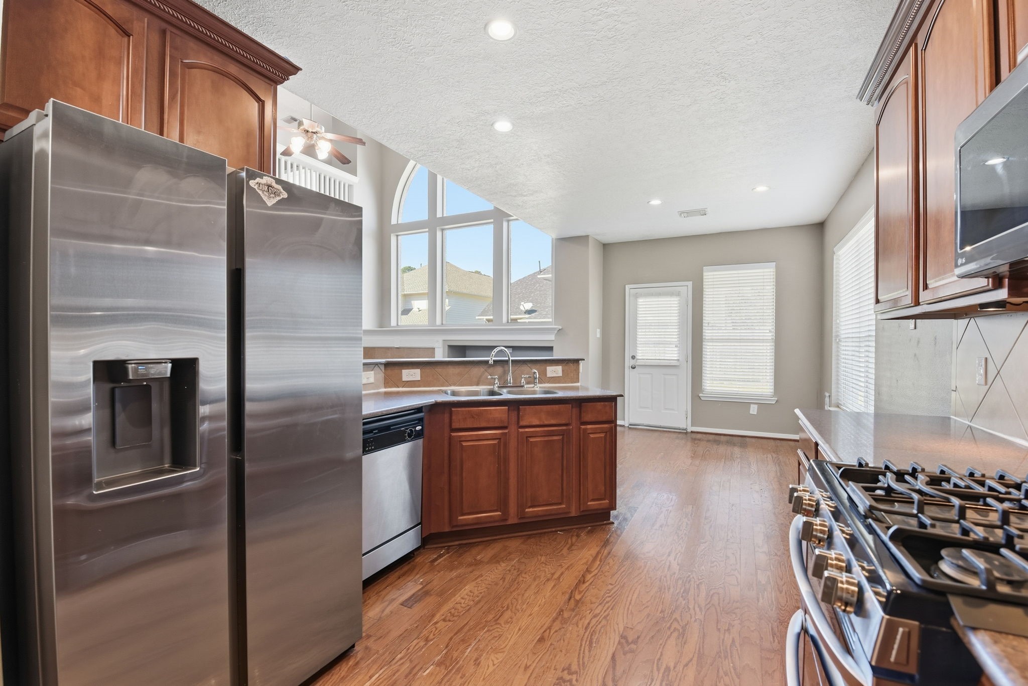 13902 Oneida Court Cypress, TX 77429 - Photo 13 of 48 a kitchen with stainless steel appliances granite countertop a refrigerator and a stove top oven