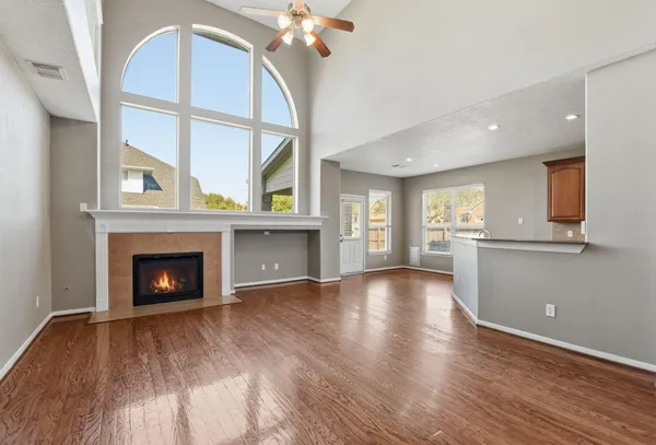 a view of an empty room with a fireplace and a window