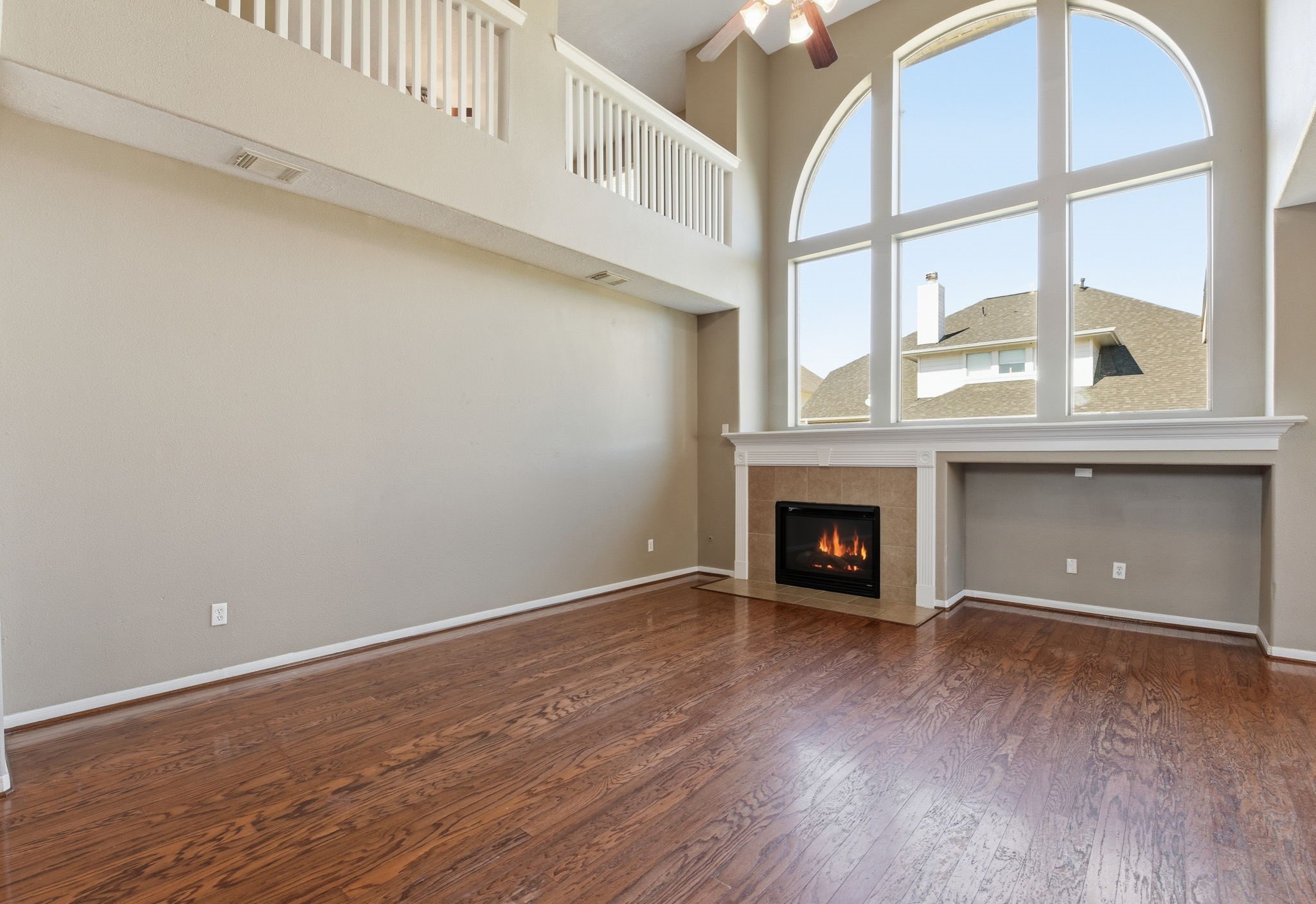 13902 Oneida Court Cypress, TX 77429 - Photo 20 of 48 an empty room with wooden floor a fireplace and windows