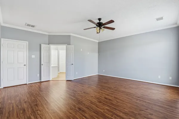 a view of an empty room with wooden floor