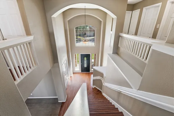 a view of staircase with wooden floor and a front door