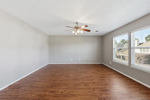 a view of a room with wooden floor and a window