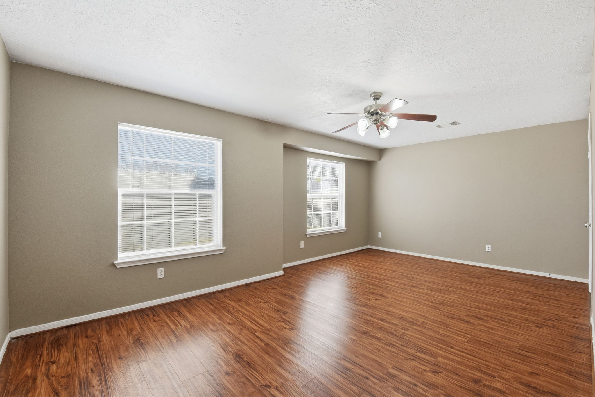 13902 Oneida Court Cypress, TX 77429 - Photo 40 of 48 an empty room with wooden floor chandelier fan and windows