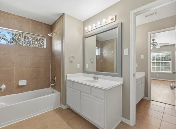 a spacious bathroom with a tub sink shower and mirror