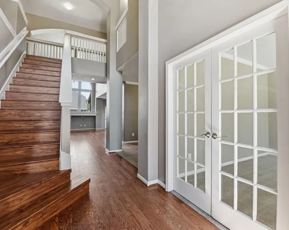 a view of a hallway with wooden floor and staircase