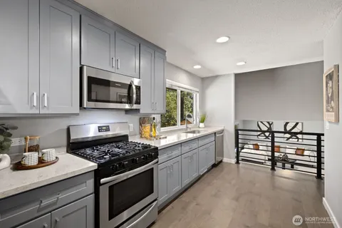 a kitchen with sink a refrigerator and chairs