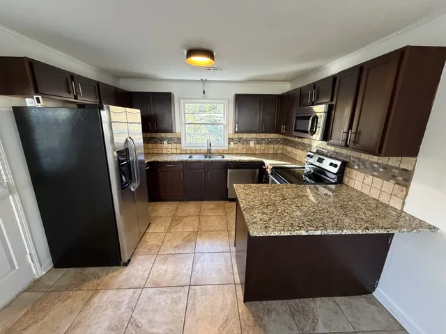a kitchen with a refrigerator sink and cabinets