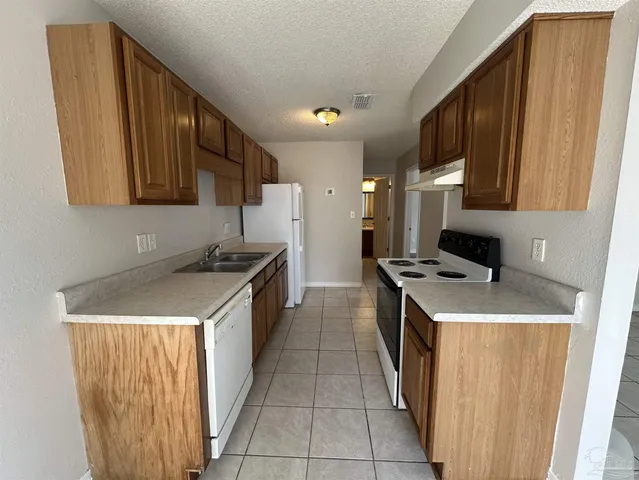 a kitchen with a stove sink and a refrigerator