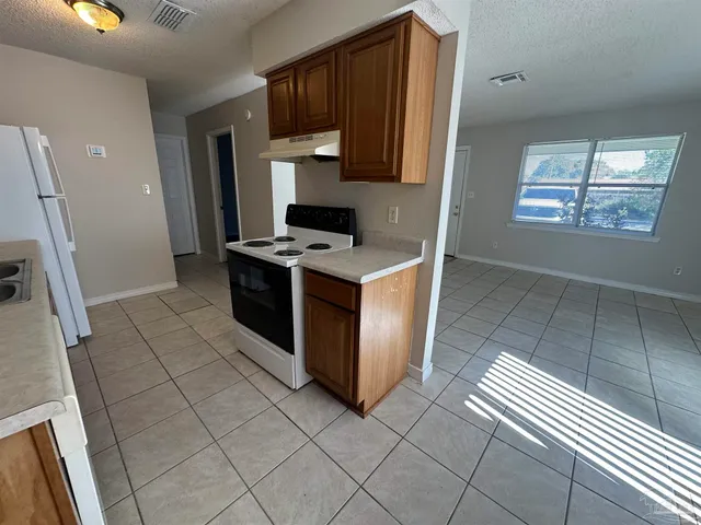 a kitchen with stainless steel appliances granite countertop a stove a refrigerator and a cabinets