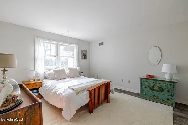 a bedroom with a bed window and a dresser