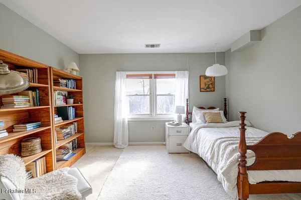 a bedroom with a bed and a book shelf