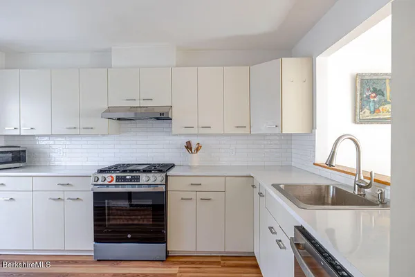 a kitchen with cabinets appliances and a sink