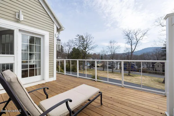 a view of a swimming pool with seating space and trees in the background