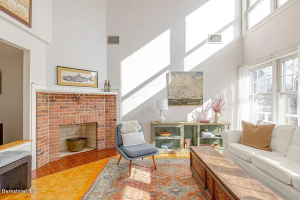 a living room with furniture a fireplace and a large window