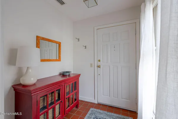 a hallway with front door wooden floor and cabinet