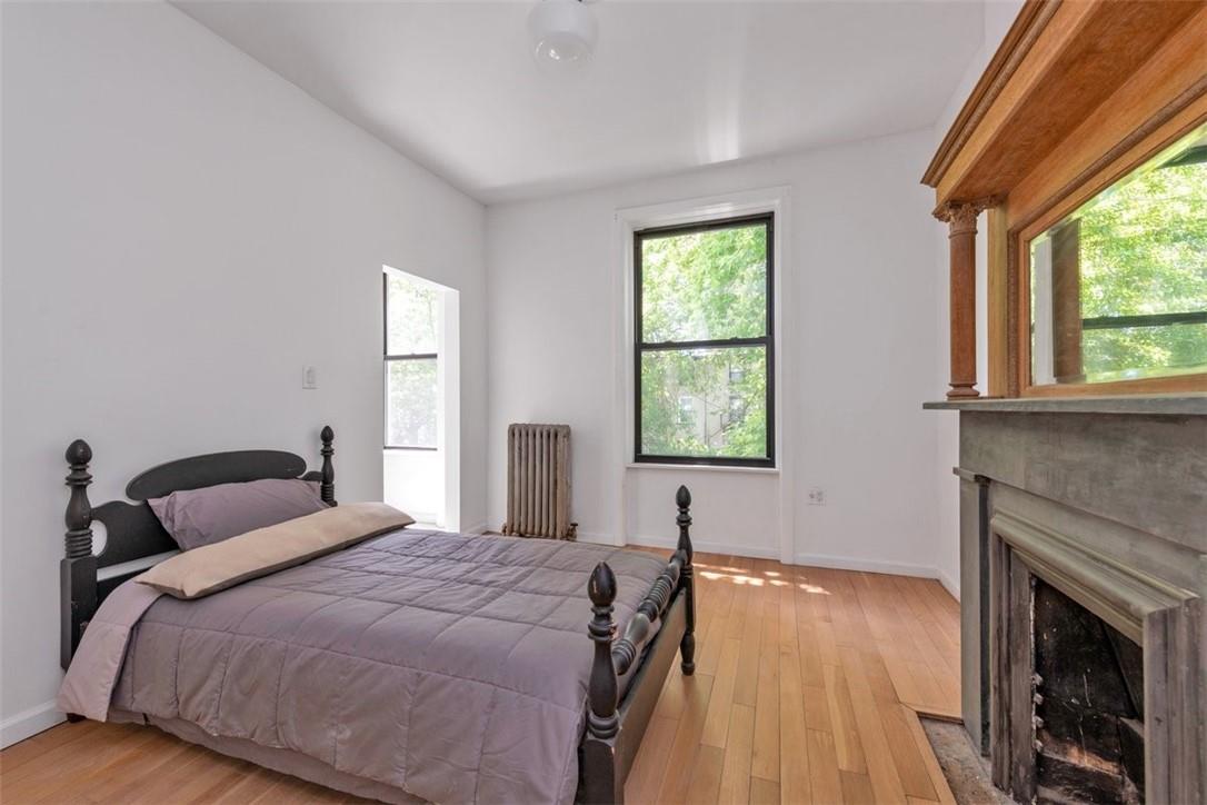 196 Decatur Street Brooklyn, NY 11233 - Photo 12 of 20 a bedroom with a bed and a fireplace