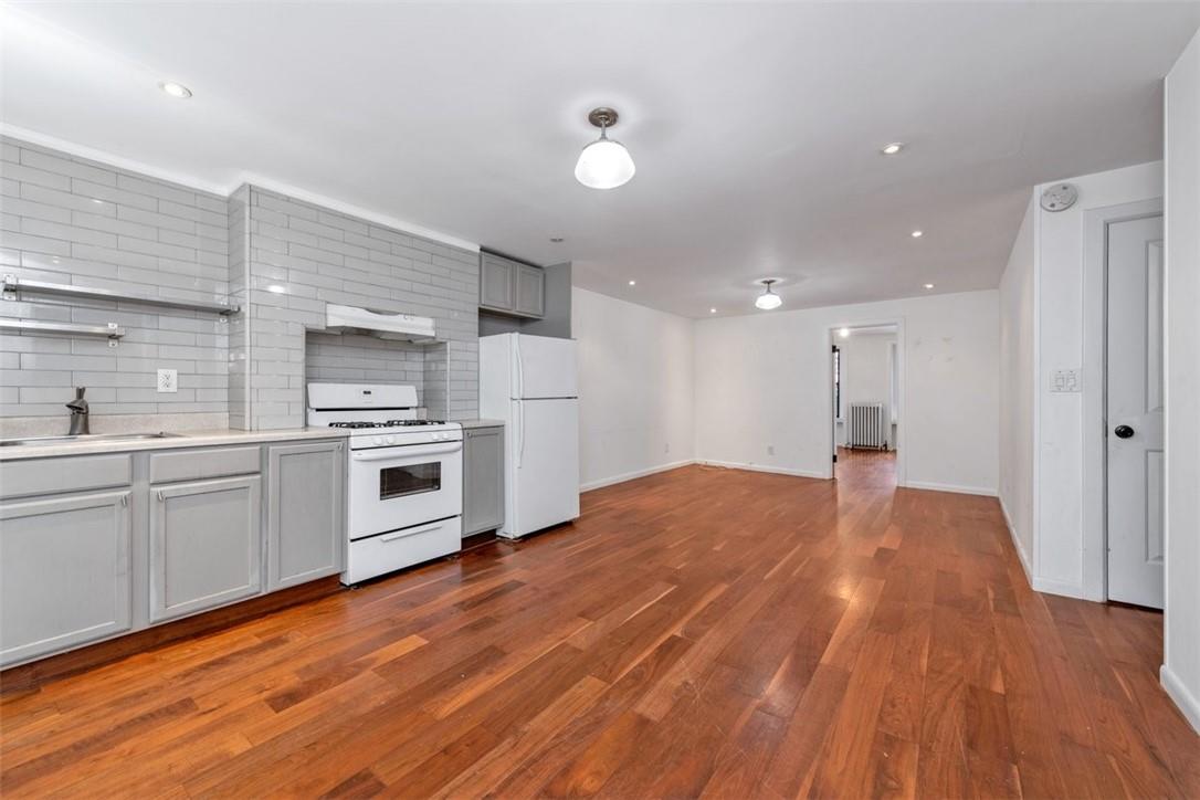 196 Decatur Street Brooklyn, NY 11233 - Photo 17 of 20 a kitchen with white cabinets and stainless steel appliances