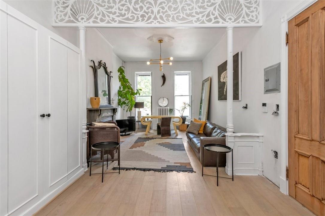 196 Decatur Street Brooklyn, NY 11233 - Photo 4 of 20 a living room with furniture a large window and a chandelier