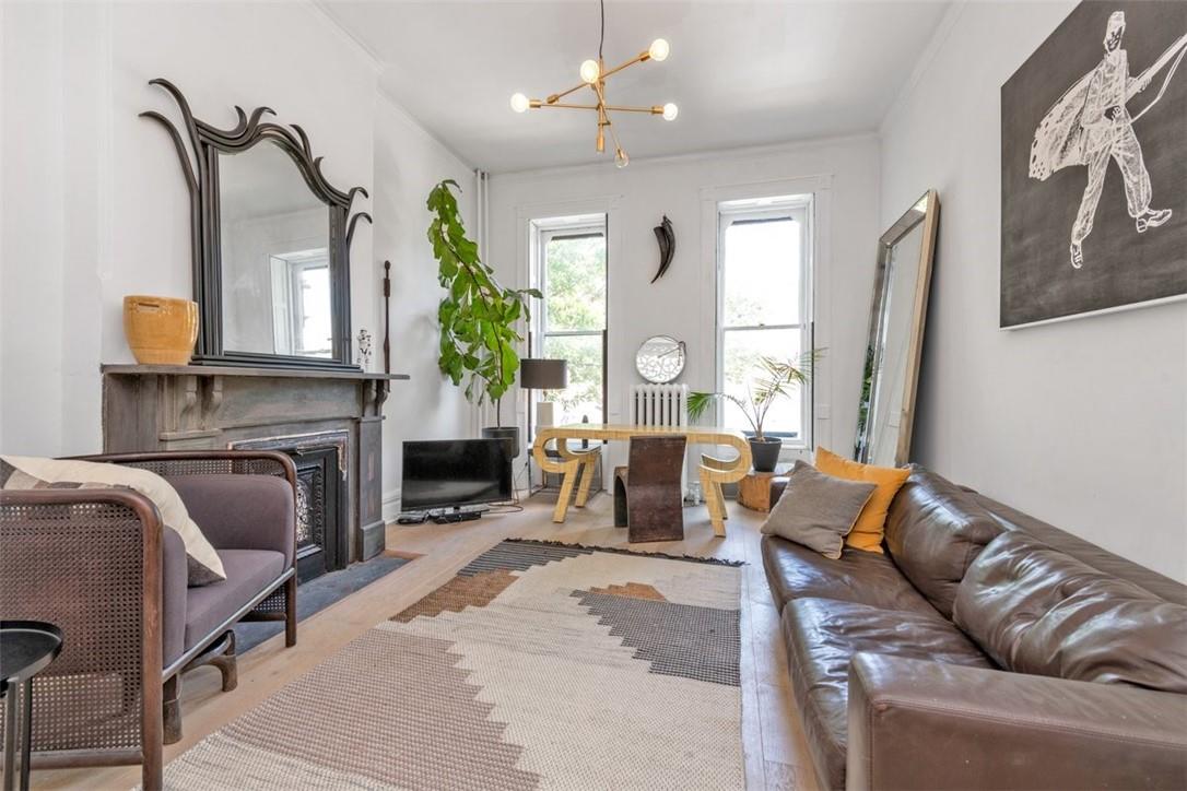 196 Decatur Street Brooklyn, NY 11233 - Photo 5 of 20 a living room with furniture a fireplace and a chandelier