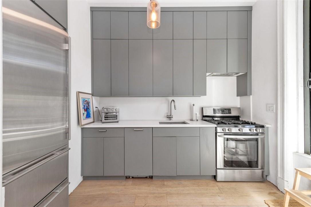 196 Decatur Street Brooklyn, NY 11233 - Photo 7 of 20 a kitchen with a stove and a refrigerator