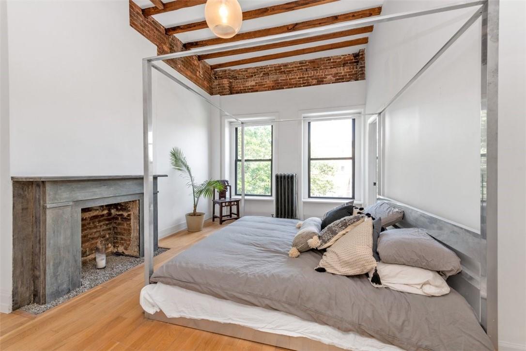 196 Decatur Street Brooklyn, NY 11233 - Photo 10 of 20 a bedroom with a bed and wooden floor