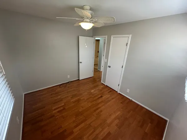 a view of a big room with closet and a ceiling fan