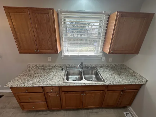 a kitchen with granite countertop cabinets sink and window