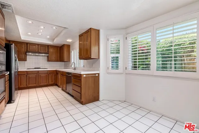 a kitchen with a sink window and cabinets